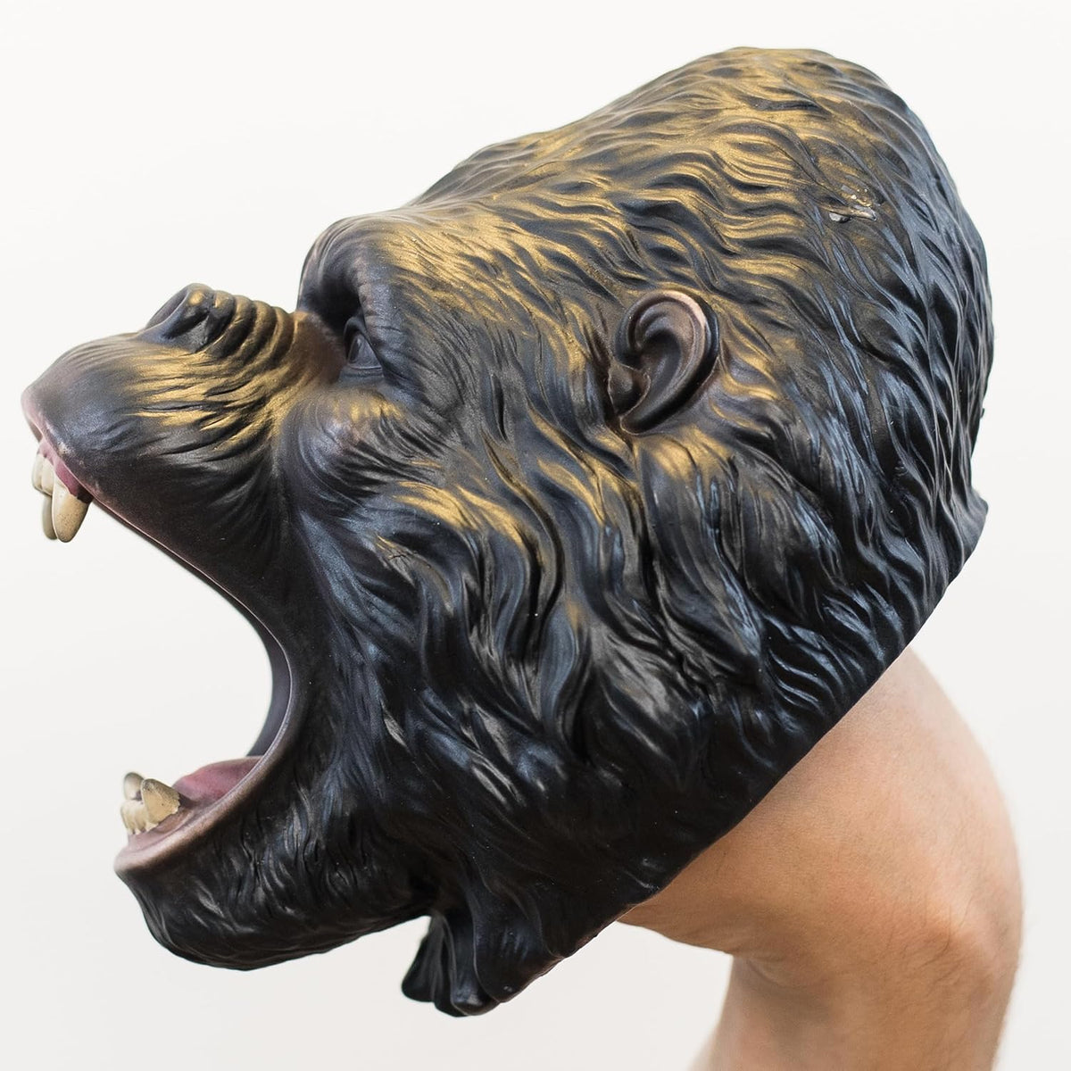 A roaring gorilla puppet with textured black and dark brown fur, shown worn on a person's hand against a plain white background.