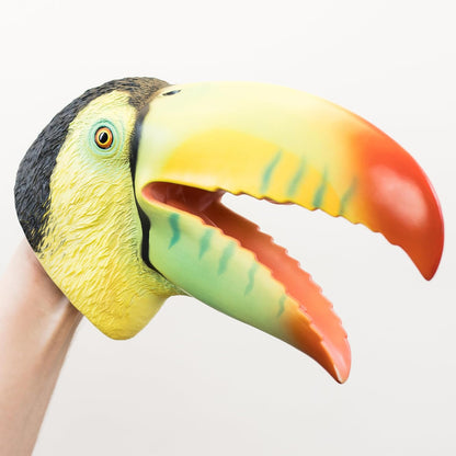 A colorful toucan head puppet being worn on a person's hand, shown against a plain light background.
