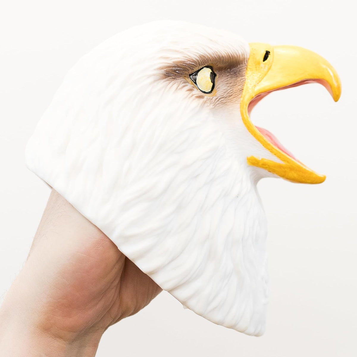 A white bald eagle head puppet being worn on a person's hand, shown against a plain light background.