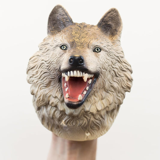 A realistic roaring wolf head puppet worn on a person's hand, shown against a plain light background.