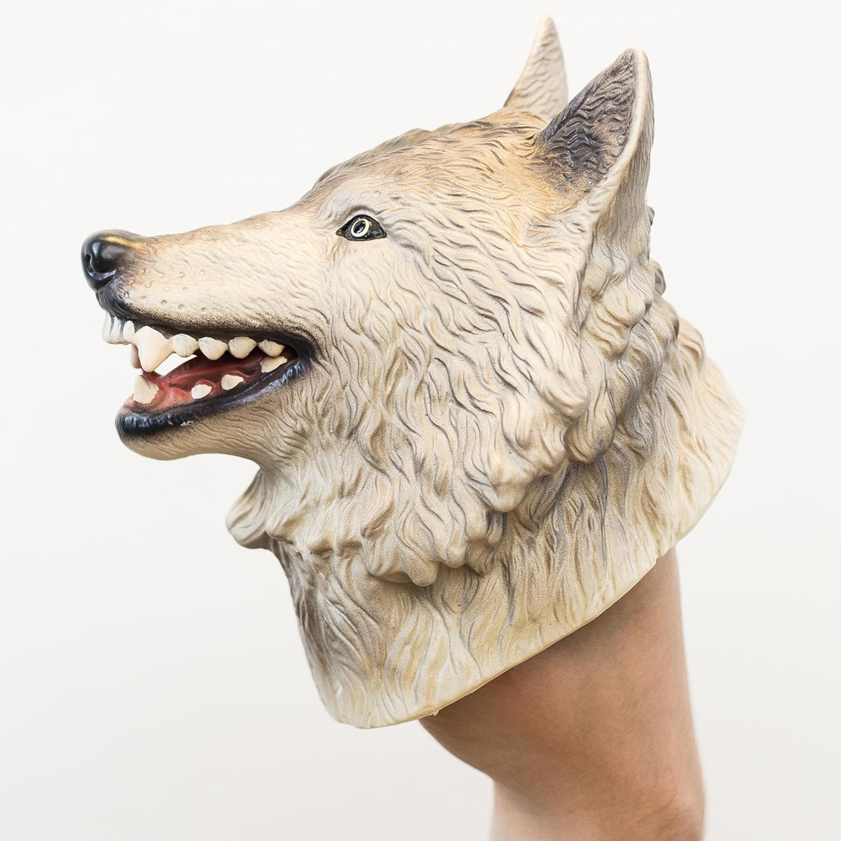 A realistic wolf head puppet worn on a person's hand, shown against a plain light background.